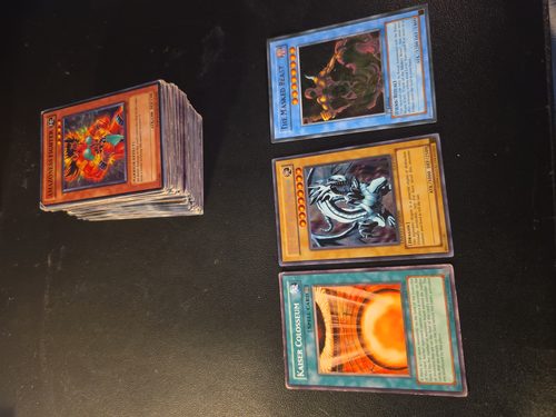Stack of trading cards submitted for assessment, several identified as reprints and counterfeits